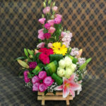 Wood arrangement with pink lilies and roses